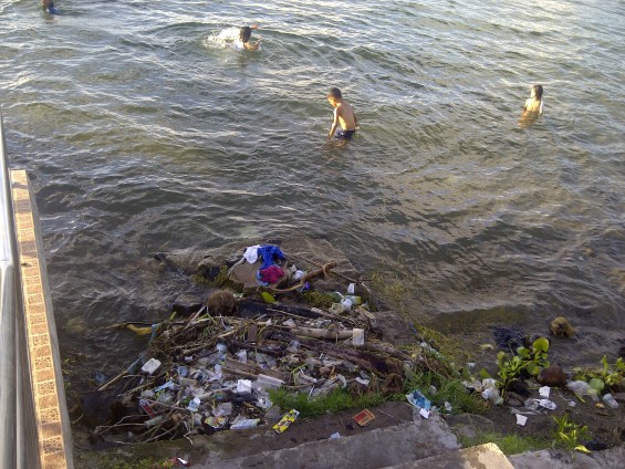 Unggukan sampah yang tak jauh dari Wisatawan yang sedang mandi di dermaga apung Danau Singkarak (tahun 2013).